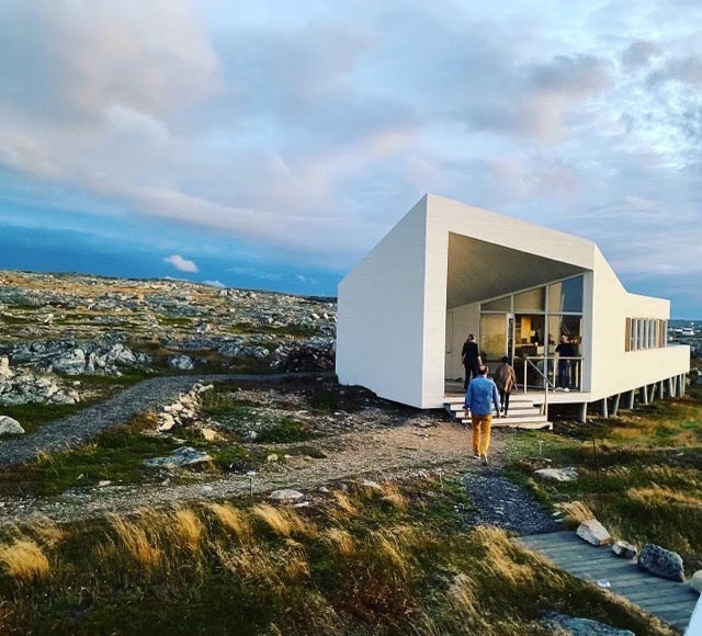 A candid shot of Amelia engaging in conversation with a local resident during the dinner, showcasing the shared meal and the warm atmosphere