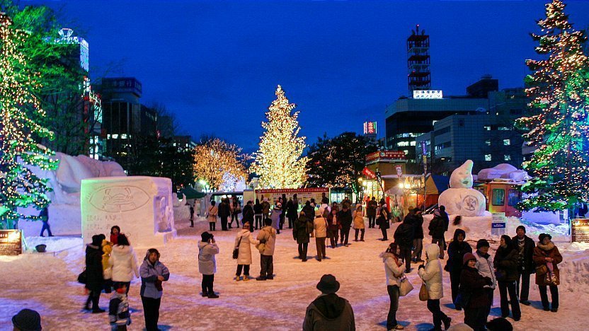 A person carefully carving a snow lantern in Sapporo during the Snow Festival