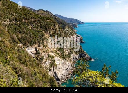 Pastel buildings with bright bougainvillea flowers cascading down the walls of Manarola