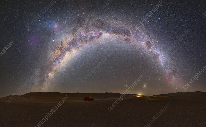 A stunning wide-angle shot of the Milky Way arching over the Atacama Desert, with the silhouette of a telescope in the foreground.