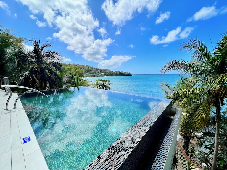 An aerial view of a pristine, secluded beach with turquoise water and a small, white-sand cove, capturing the essence of a hidden paradise.