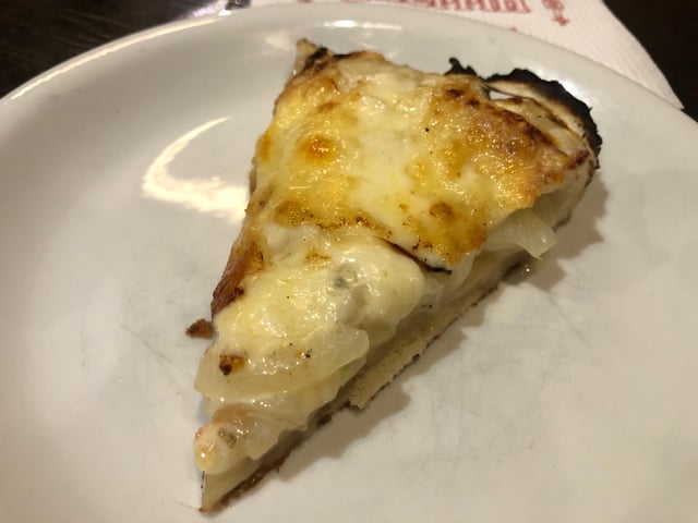 Wide-angle shot capturing the crowded interior of Güerrin, showcasing the pizza chefs in action and rows of customers enjoying their meals.