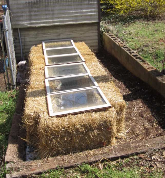 A straw bale cold frame with an open window.