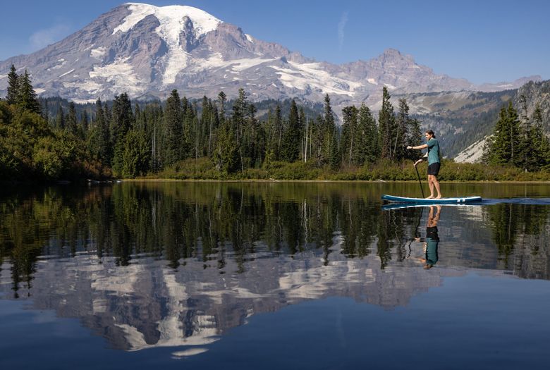 Sarah and Alex paddling on Lake Cushman with snow-capped mountains in the background.