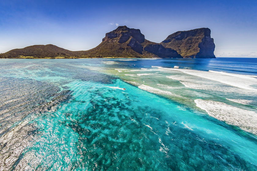 Snorkeler surrounded by fish at Ned's Beach, Lord Howe Island