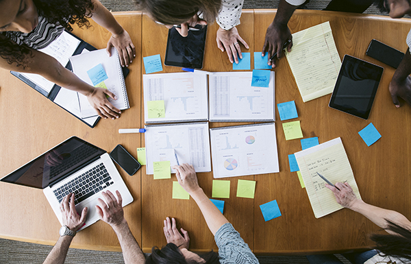 Two students collaborating on a coding project, smiling and working together on a single laptop