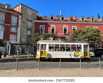 A picturesque view of Lisbon with its iconic red-tiled rooftops and a glimpse of the Tagus River, capturing the city's charm and beauty.
