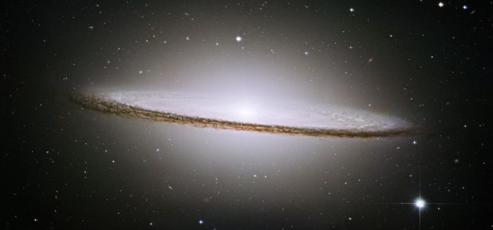 Inside the yurt at night, illuminated by a single solar-powered lamp. Dr. Sharma reviews astrophotography results on her laptop, the cool blue light contrasting with the warm tones of the yurt.