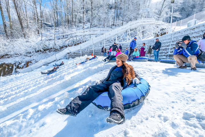 Night Snow Tubing with LED Lights and Music at Ober Gatlinburg Ski Area, Tennessee, USA: Tubers speed down a hill illuminated by vibrant LED lights synced to music, capturing the festive and fun atmosphere of night snow tubing.