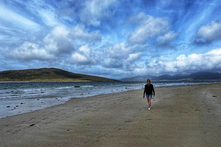 Anya walking alone on the vast Luskentyre Beach, finding resilience in nature