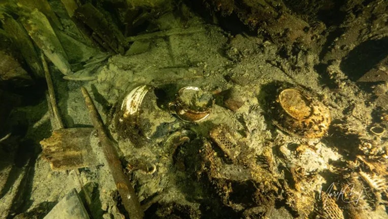 A diver exploring the decaying remains of an ancient shipwreck in the Baltic Sea. Visibility is low, highlighting the murky conditions.