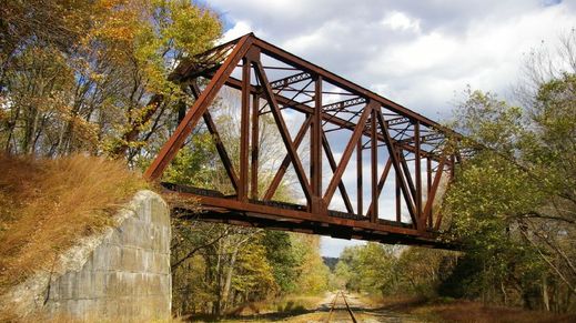 Arched stone bridge spanning a river, representing the subtle yet imposing architecture often associated with Bilderberg meeting locations.