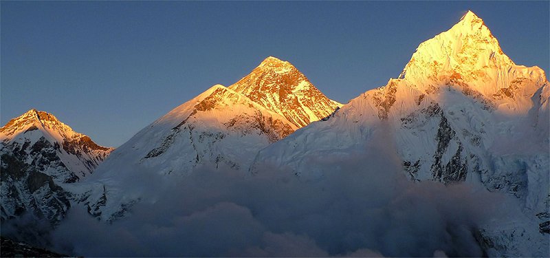 Sunrise over snow-capped Himalayan peaks with prayer flags