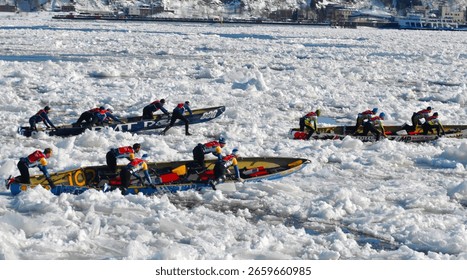 An ice canoeing team paddles and pushes their canoe across the icy St. Lawrence River, with Quebec City visible in the background. This image demonstrates the teamwork and determination required for this challenging winter activity.