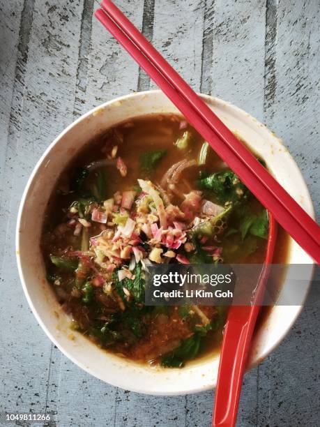 A close-up shot of Penang Road Famous Laksa, showcasing the vibrant colors of the broth, toppings, and noodles, highlighting the dish's appetizing appeal.
