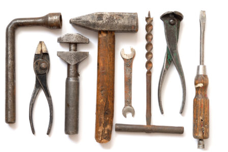 Hands cleaning up a rusty, old gardening tool