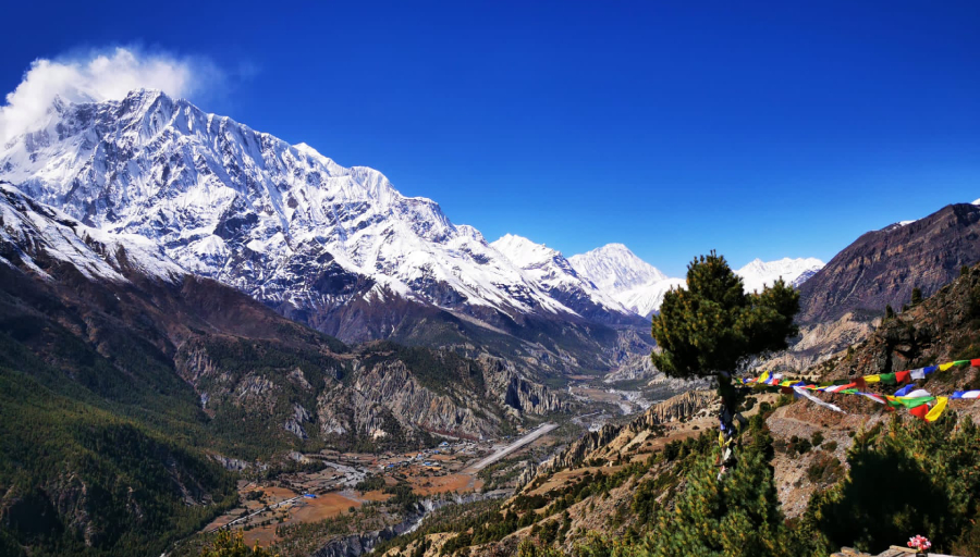 Panoramic view of the Annapurna mountain range, showing snow-capped peaks and a clear blue sky