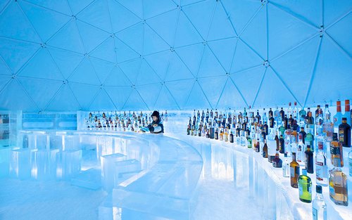 An outdoor onsen (rotenburo) at a Ryokan in Akan Onsen, surrounded by snow, creating a serene and relaxing atmosphere.