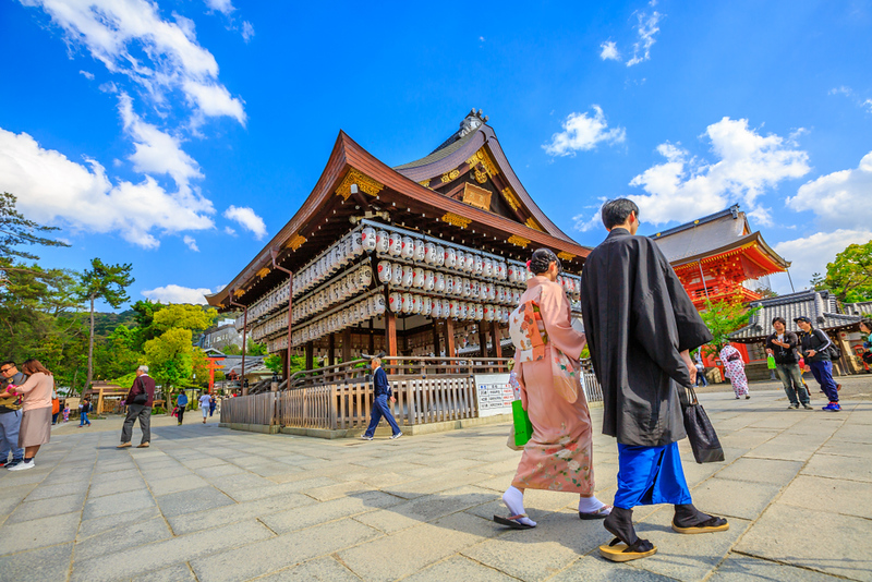 A couple enjoying a picnic under cherry blossoms in a Kyoto park