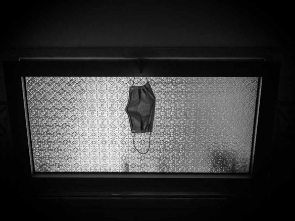 The hostel's facade, painted a faded ochre with dark green window shutters, and a view of a cobbled street