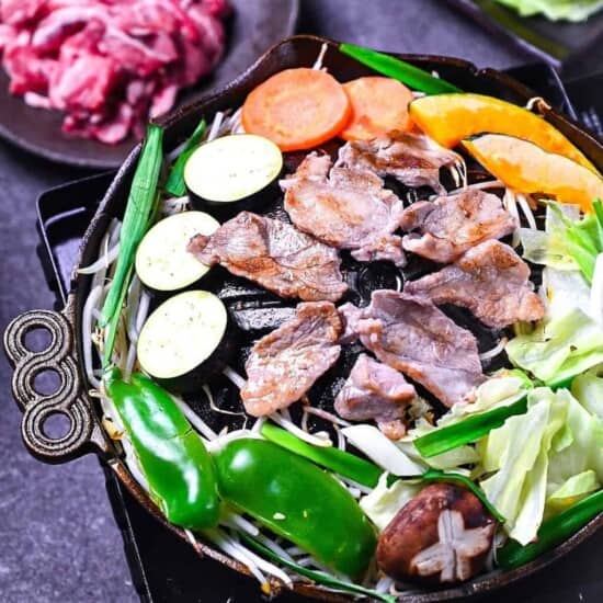 An action shot of a snowboarder or skier enjoying powder snow at Furano, with a clear view of the surrounding landscape.