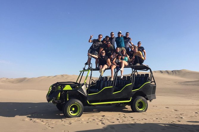 sandboarders navigate the steep dunes of Huacachina oasis, demonstrating the adventure activity available