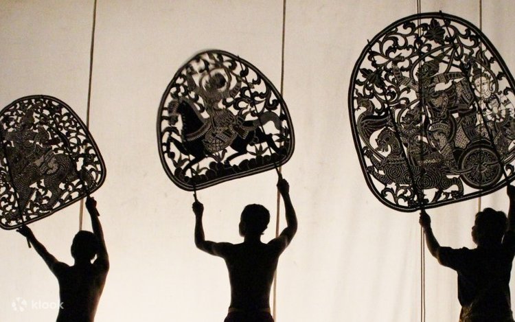 A street vendor in Siem Reap preparing Lort Cha, the Cambodian fried noodles, on a wok with visible smoke and vibrant ingredients.