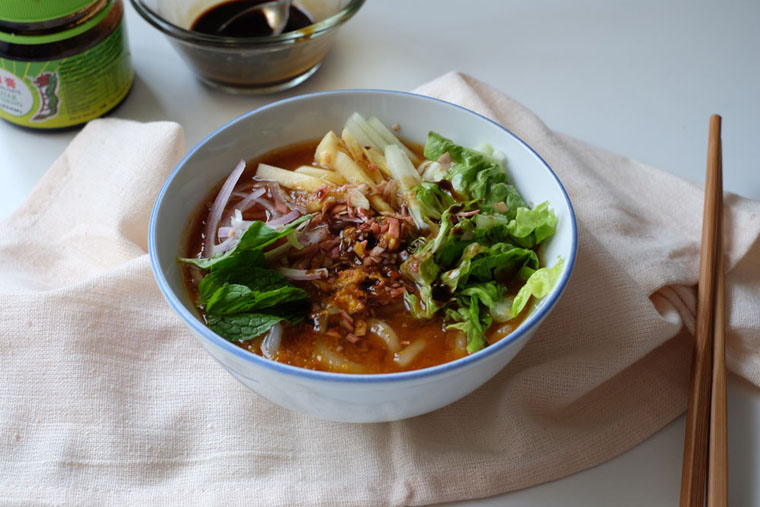 A bowl of Assam Laksa with its distinctive tangy broth and ingredients