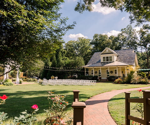 A picturesque cream cottage with wraparound porch