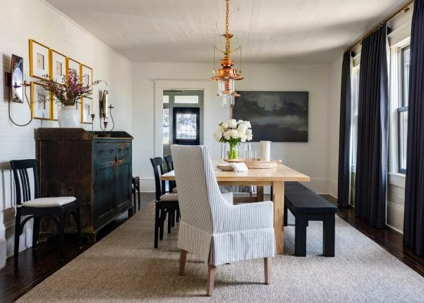 A farmhouse dining room, showcasing a traditional fireplace and dark accents.