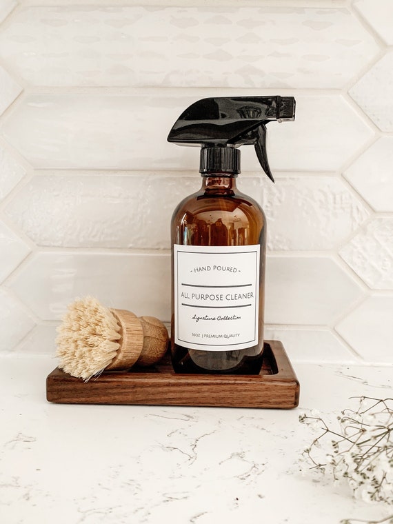 Various homemade citrus cleaning products displayed on a shelf in glass bottles