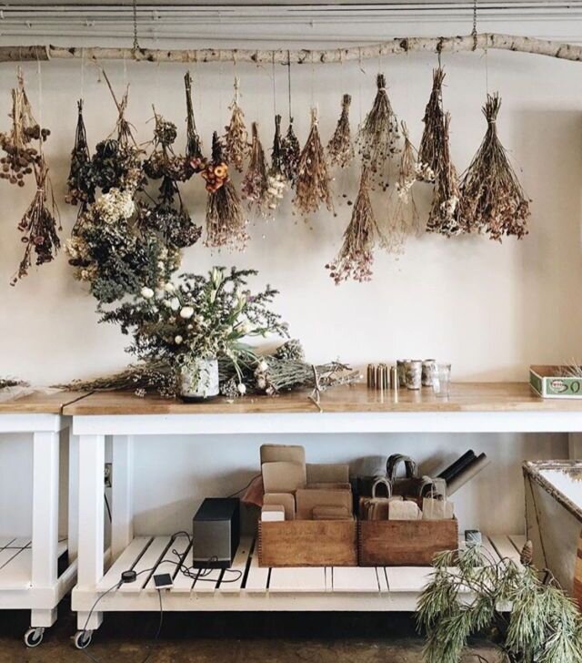 Overhead, instructional photographs showing step five in creating the hanging herb drying rack. The image is well-lit (using diffused natural light from a north-facing window), and clearly shows the materials and process, focusing on the textures of the reclaimed wood, the details of the copper wire, and the use of the drill and pliers. Maintain a clean, uncluttered background. Quality should be 4k, high resolution, professional photography, shot with a Nikon D850 and a macro lens.