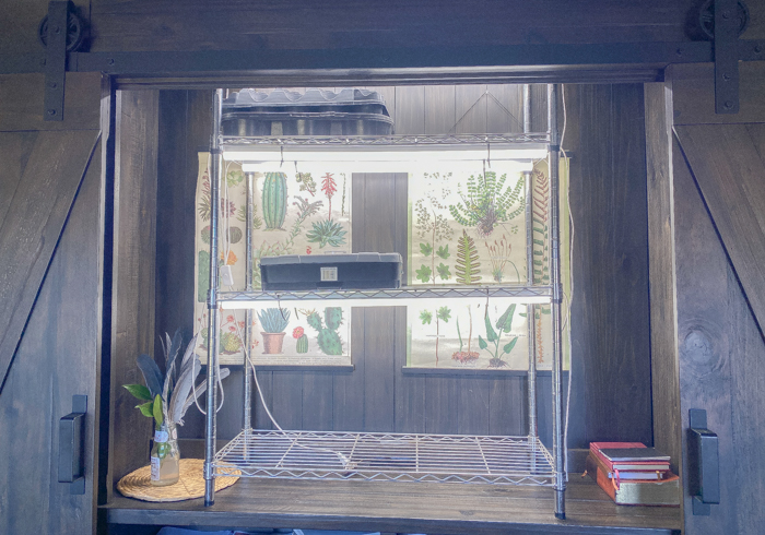 A seed starting shelf with adjustable shelves, drip trays, and a small fan for ventilation.