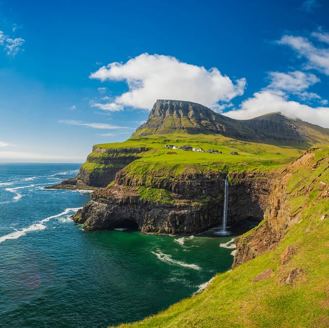 Dr. Astrid Olsen using binoculars to observe seabirds at the Vestmanna bird cliffs.