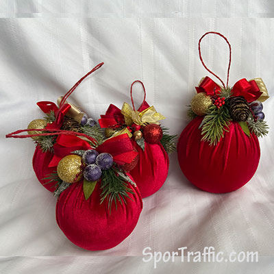 Several finished pinecone ornaments hanging on a Christmas tree, lit with warm white lights, creating a cozy and festive holiday scene