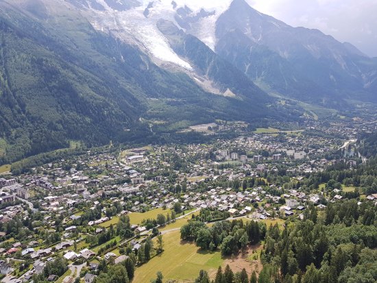 Speed Riding in Chamonix, France: A speed rider soars down a snow-covered slope in the French Alps, showcasing the combination of skiing and paragliding with Mont Blanc in the background.