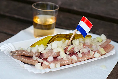 A vendor at the Albert Cuyp Market preparing a herring sandwich