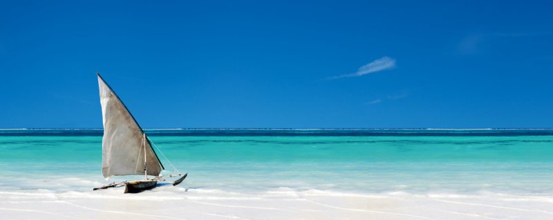 Zanzibar's crystal-clear turquoise water and white sand beaches under a clear blue sky