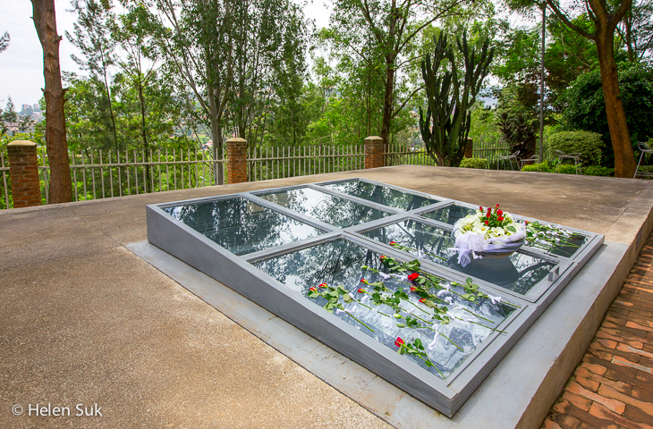 Entrance to the Kigali Genocide Memorial with a serene garden and flags flying.