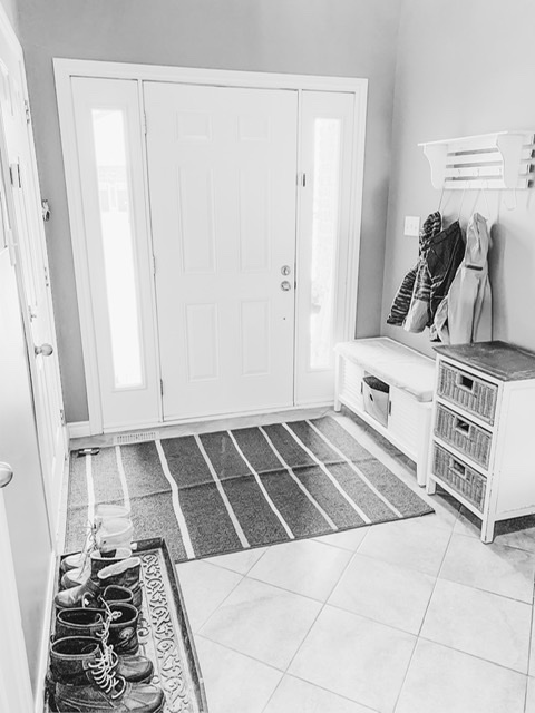 A small dehumidifier placed in the corner of a mudroom to prevent mold and mildew.