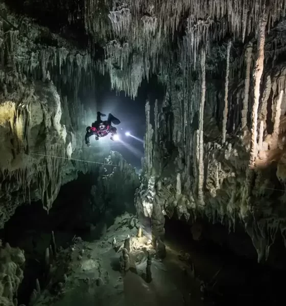 Woman floating in a cenote while sound healing instruments are played