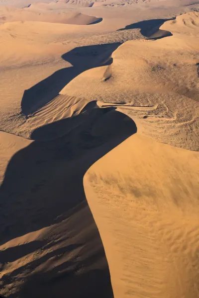 Aerial view of the Namibian desert dune sea, showcasing the stunning patterns and textures formed by wind and sand.