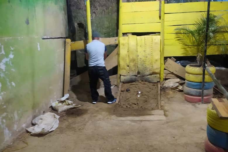 Anya enthusiastically throwing a tejo disc, surrounded by locals, with a target exploding in the background