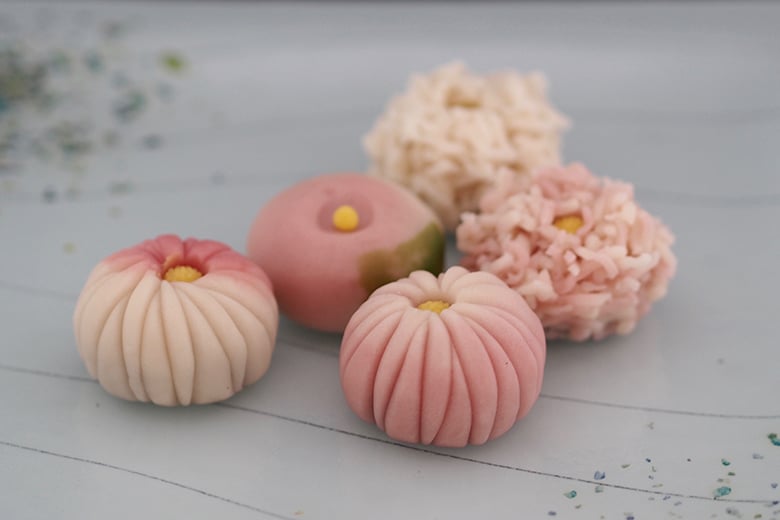 Close-up of a variety of colorful and intricately designed wagashi, highlighting the detail and artistry of the sweets.