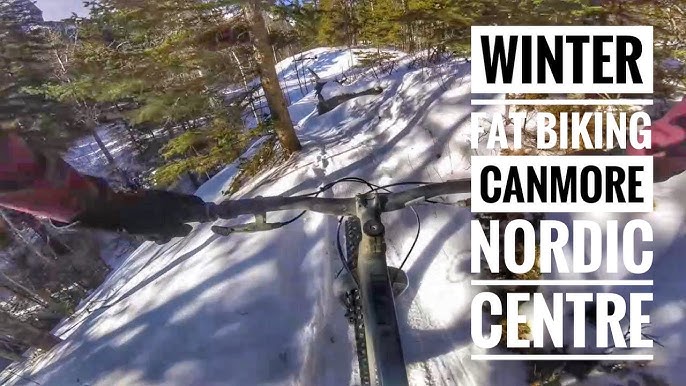 An action shot of a fat biker riding through a snowy trail in Canmore