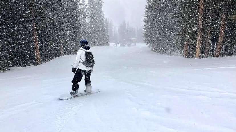 A person snowshoeing in a snowy mountain landscape, highlighting the blend of adventure and scenic beauty available in winter destinations