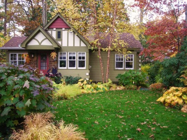 A welcoming front porch decorated for fall with pumpkins and mums