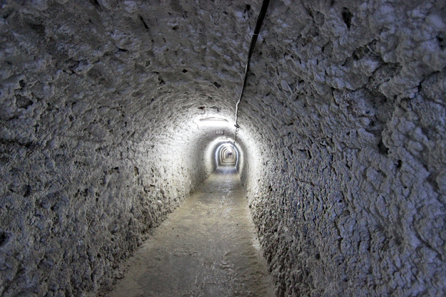 An interior shot of the Turda Salt Mine, emphasizing the immense scale and dramatic lighting within the underground chambers.