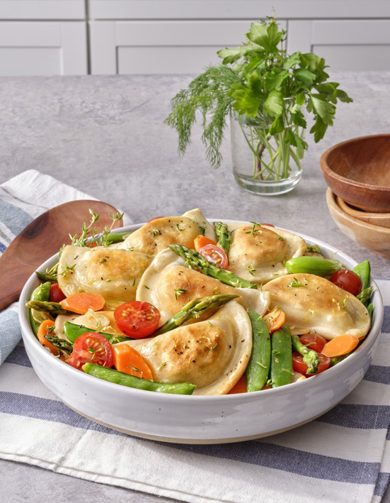Sliced heirloom tomatoes are carefully arranged over a layer of goat cheese and Parmesan cheese on a puff pastry crust.
