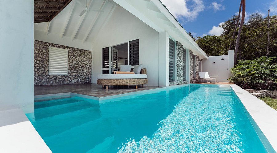 A woman walking on a black sand beach on Tanna Island with a local guide